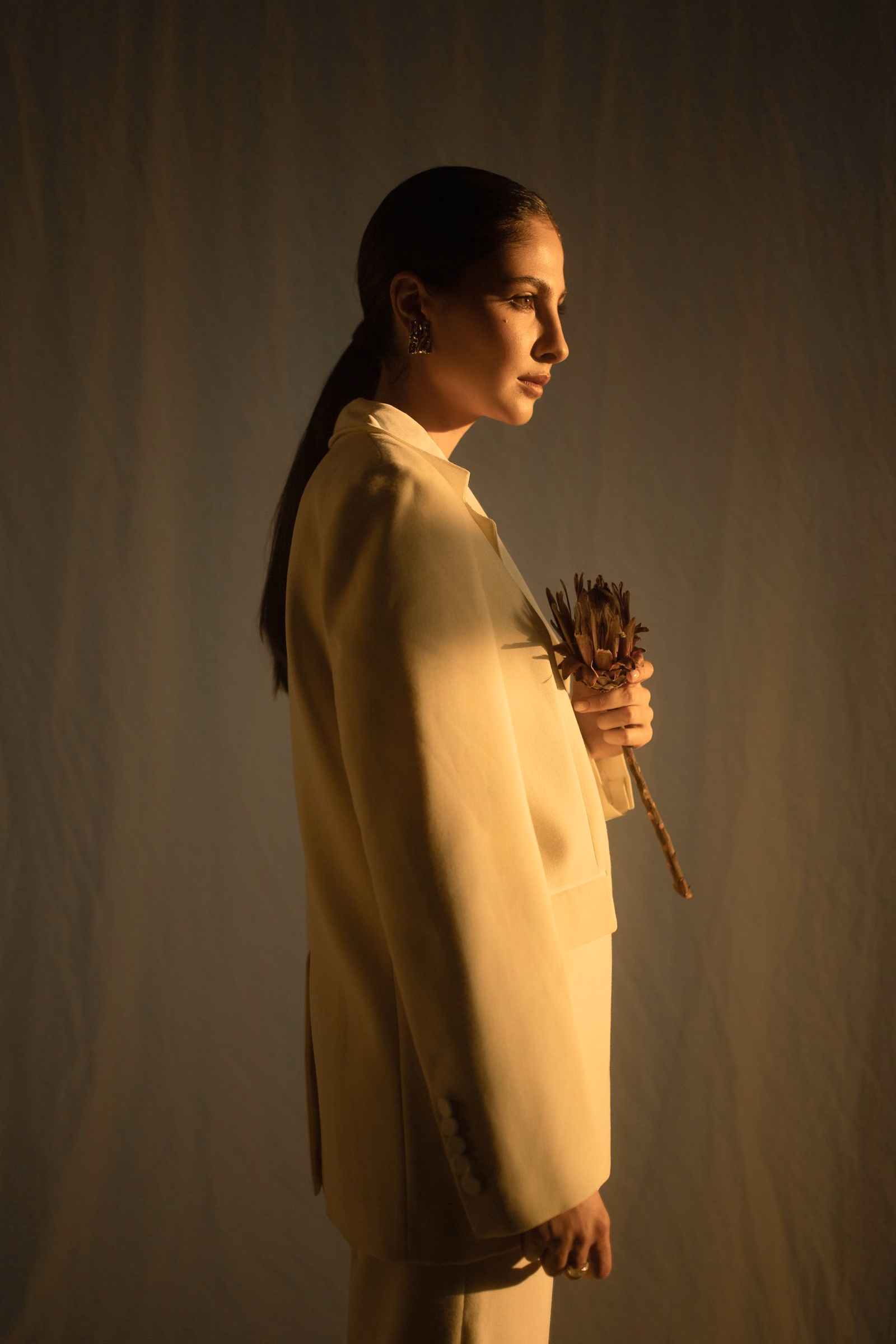 Mulher de blazer creme em luz quente, perfil