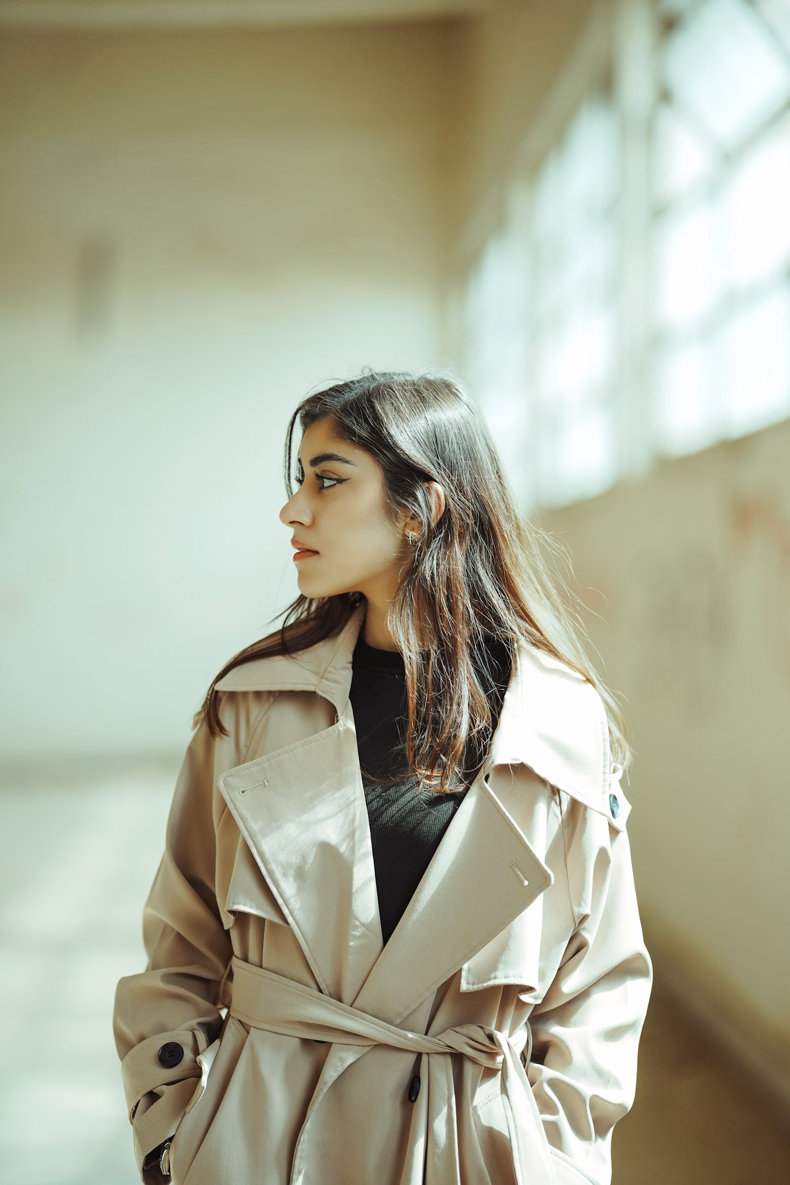Mulher de trench coat bege, perfil, luz suave